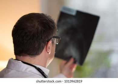 Back Turned Concentrated Radiologist Reading X-ray Images