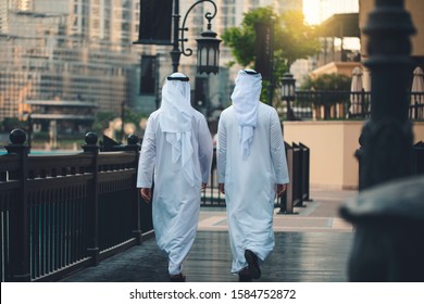 back of two Arabic men walking in Dubai downtown 