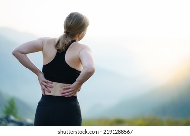 Back view of adult runner woman suffering from Backache or Sore waist after running. - Shutterstock ID 2191288567