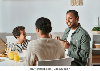 back view of african american woman enjoying delicious breakfast with her jolly son and husband - Powered by Shutterstock