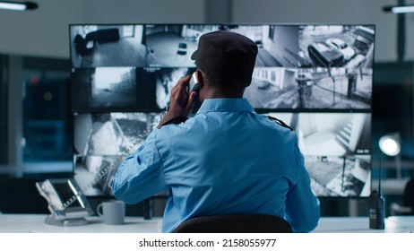Back view of African-American security officer in system control room answer phone call - Shutterstock ID 2158055977