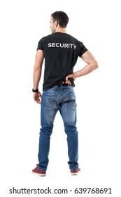 Back View Of Alerted Undercover Cop Or Security Agent Reaching Hand Gun Attached On Belt. Full Body Length Portrait Isolated On White Studio Background. 