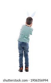Back view of amazed fascinated young boy with Easter bunny ears watching away with head in hands. Full length isolated on white background.