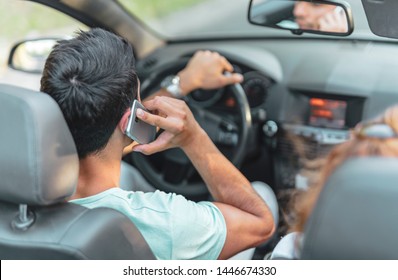 Back View Of Arab Male Driving And Talking On His Cell Phone. Dangerous Behavior Of Male Driver Driving And Talking On His Mobile Phone.