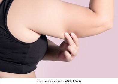 back view. asian fat women has overweight. she used hands squeezing excess fat of the arms. isolated on violet background. she wants lose weight. concept of surgery and subcutaneous fat breakdown.