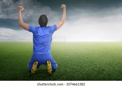 Back view of asian footballer man celebrate his goal on the field - Shutterstock ID 1074661382