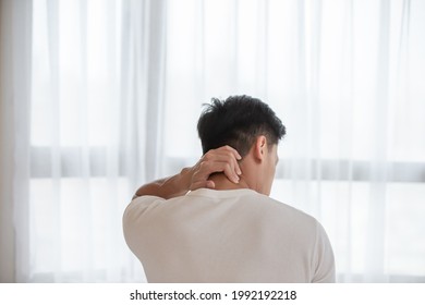 back view of asian man has neck and shoulder pain after wake up in the morning at home - Powered by Shutterstock