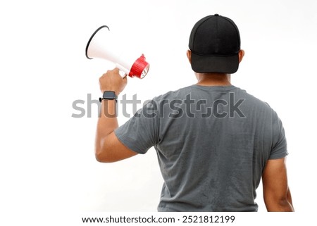 Back view of asian man standing while holding a megaphone. Protest concept