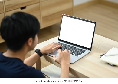 Back View Of Asian Man Surfing Internet, Working Online On Laptop At Home