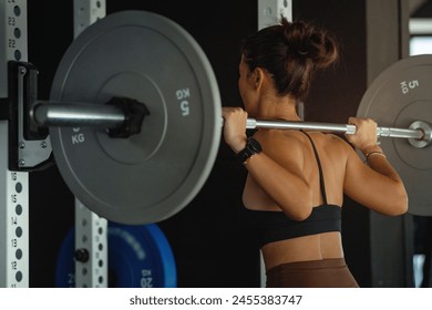 Back view, Asian sporty woman lifting weight barbell in gym, sporty woman exercising - Powered by Shutterstock