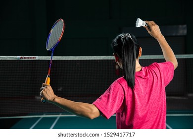 Back View Asian Woman Badminton Player Holding Racket And Shuttlecock Ready To Serve In Badminton Court, Most Popular Indoor Sport In Southeast Asia,serving Action,female Sporty Athlete,sports Concept