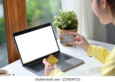 Back View Of Asian Woman In Casual Outfit Entering Typing Credit Card Number On Laptop To Purchase Items From An Online Store, Order Food, Pay Bills, Empty Screen Of Laptop.