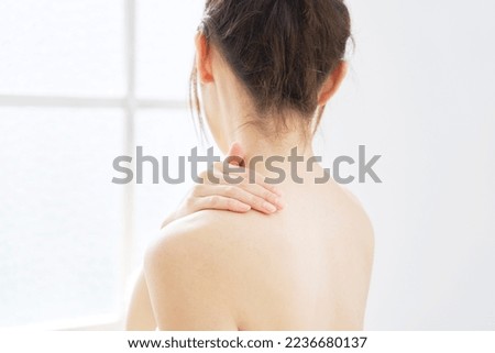 Back view of Asian woman taking care of her back