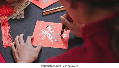 back view of asian woman write spring festival couplet to celebrate Lunar new year with word meaning Dragon - Powered by Shutterstock