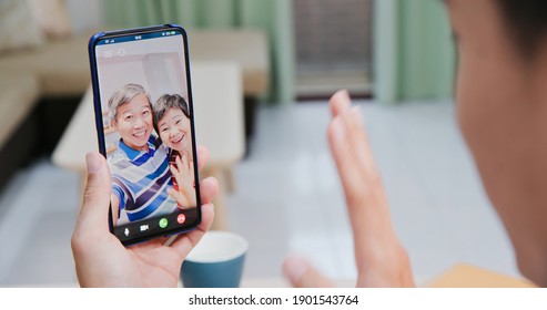 Back View Of Asian Young Man Has Video Chat With Father And Mother By Smart Phone At Home Happily