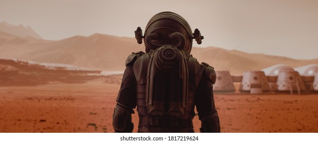 Вид сзади космонавта в скафандре, идущего по поверхности красной планеты. Марсианская база и марсоход на заднем плане. Концепция колонизации Марса