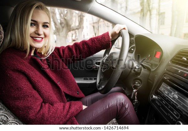 Back view of an attractive
young business woman looking over her shoulder while driving a
car