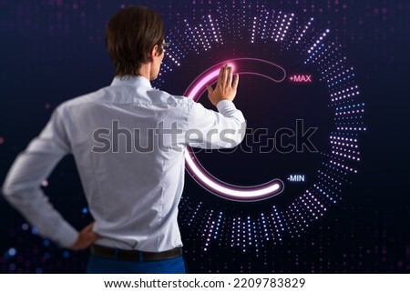 Back view of attractive young european businessman using abstract glowing max and min scale hologram on dark background. Volume control and future concept