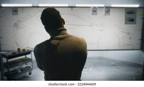 Back View Of Automotive African American Male Designer Drawing Sketch Blueprint With Marker, Developing Futuristic Electric Car Design On Whiteboard. Work In Modern Car Design Development Studio.