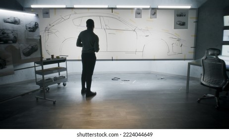 Back View Of Automotive African American Male Designer Drawing Sketch Blueprint With Marker, Developing Futuristic Electric Car Design On Whiteboard. Work In Modern Car Design Development Studio.