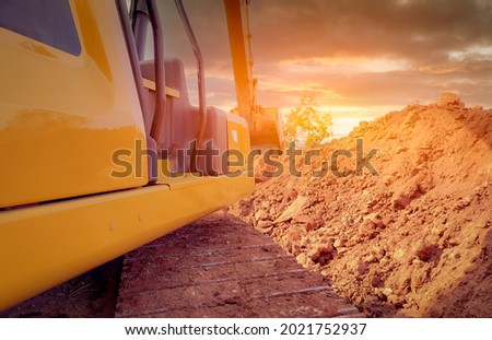 Back view backhoe working by digging soil at the construction site. Crawler excavator digging on demolition site. Excavating machine. Earthmoving equipment. Excavation vehicle. Construction business.