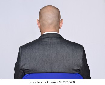 Back view from a bald head businessman siting on white background.