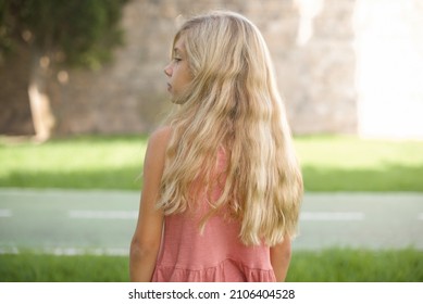 The back view of beautiful Caucasian little kid girl wearing dress standing outdoors  Studio Shoot. - Powered by Shutterstock