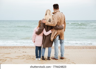 Back view of a beautiful family with a little daughter having fun at the beach together స్టాక్ ఫోటో
