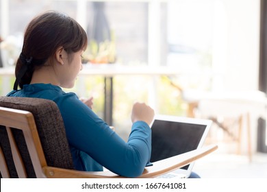 Back view beautiful of portrait happy young freelance asian woman using laptop work with success in the home, asia girl and notebook shopping online with glad, communication concept.