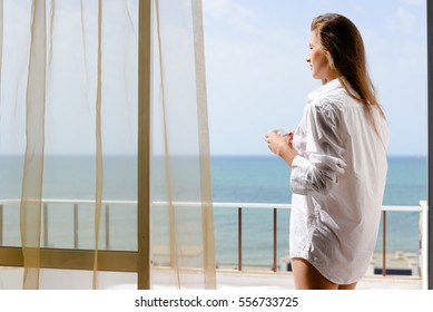 Back view of beautiful woman luxury relaxing enjoying cup of coffee tea on blue sky sea outdoors background