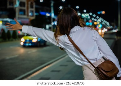 Back View, Beautiful Woman Smiling Using Smartphone Application Hailing With Hand Up Calling Cab Outdoor After Late Work, Asian Business Woman Hail Waving Hand Taxi On Road In City Street At Night