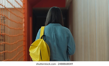 Back view from behind moving walking going Caucasian student girl female schoolgirl woman pupil teenager teen with schoolbag bag backpack walk go in school university college corridor education study - Powered by Shutterstock