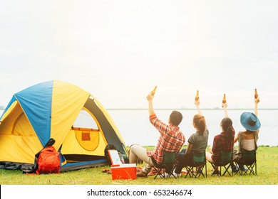 Back View Of Best Friends Raised Arm With Bottle Of Beer To Celebrate While Camping During Travel.Friendship Concept.