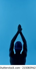 Back View Of Black Boy Swimmer In Swim Pose. Partial Image Of Male Youngster Wearing Swimming Cap And Goggles. Modern Child Sportive Lifestyle. Isolated On Blue Background. Studio Shoot. Copy Space