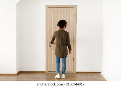 Back View Of Black Female Opening Door Of Her Apartment Standing Indoor. Unrecognizable Lady Locking Her Apartment. New Home, Real Estate Purchase And Ownership Concept. Full Length Shot