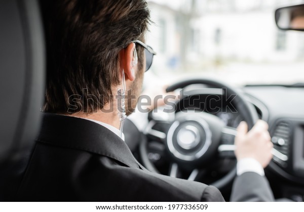 back view of\
bodyguard driving modern\
automobile