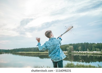 Back View Of Boy In Denim Jacket Playing With Baseball Bat Outdoors