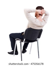 Back View Of Business Man Sitting On Chair. Bearded Man In A White Warm Sweater Sits On A Chair With His Hands Behind His Head. Side View.