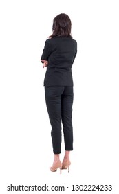 Back View Of Business Woman In Black Suit With Crossed Arms Watching Interested. Full Body Isolated On White Background. 