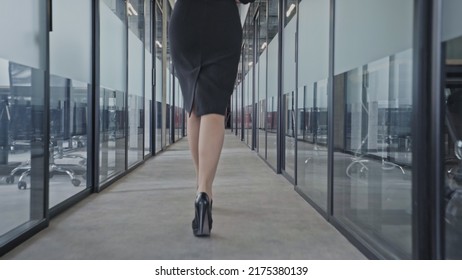 Back view of business woman on high heels walking along corporate building corridor - Powered by Shutterstock