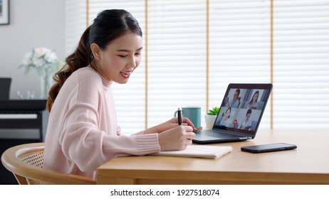Back view of business woman talking about sale report in video conference. Asian team using laptop and tablet online meeting in video call.Working from home, Working remotely and Social isolation. - Shutterstock ID 1927518074