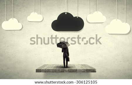 Back view of businessman with black umbrella and black cloud above