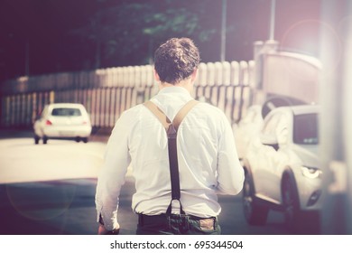 back view of businessman in the city, young male with braces walking on a busy city