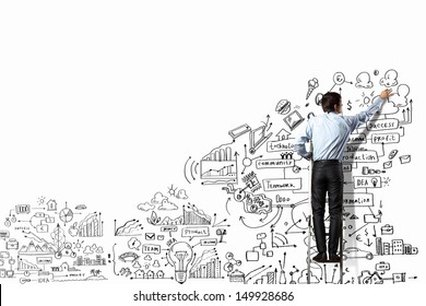 Back view of businessman drawing sketch on wall
