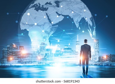 Back View Of Businessman In Night City Looking At Globe With Network. Global Networking And International Business Concept