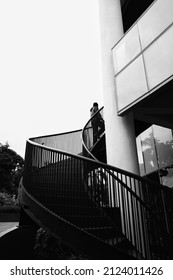 Back View Of Businessman Walking Up Staircase. Back To Office Or Climbing Up The Corporate Ladder Concept Black And White Photography Concept