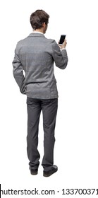 Back View Of A Businessman Who Is Looking Into The Smartphone.  Isolated Over White Background. Backside View Of Person. A Young Businessman In A Tweed Suit Reads From A Phone Screen.