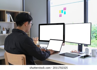 Back View Of Businessman Working With Multiple Modern Gadget At Home Office.