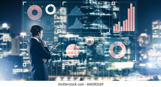 Back view of businessman working with virtual panel and night city at background