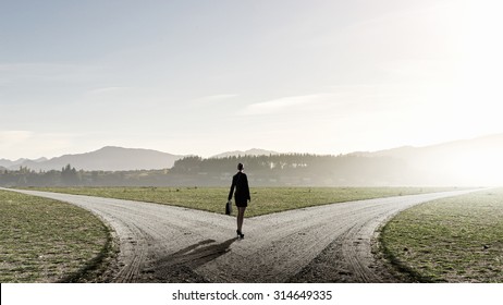 Back View Of Businesswoman Standing On Crossroads And Making Choice